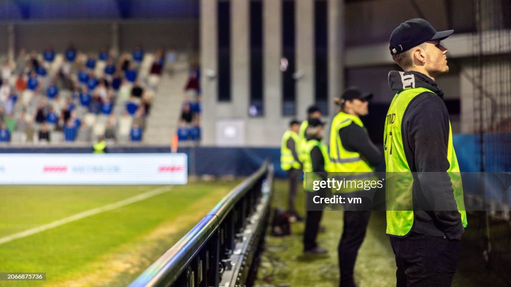 Security Team Supervising Football Match at Night