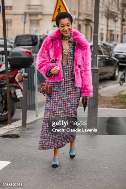 Tamu Mcpherson wears colorful tweed long dress, fuchsia fur jacket, brown Chanel bag, denim heels, outside Chanel, during the Womenswear Fall/Winter...