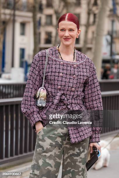 Marianne Theodorse wears pink tweed jacket, military print pants, sequins Chanel bag, outside Chanel, during the Womenswear Fall/Winter 2024/2025 as...