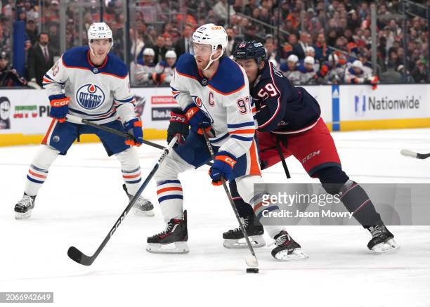 Connor McDavid of the Edmonton Oilers skates with the puck against Yegor Chinakhov of the Columbus Blue Jackets during the first period at Nationwide...