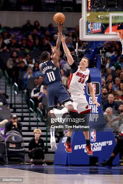 Tim Hardaway Jr. #10 of the Dallas Mavericks shoots the ball against Duncan Robinson of the Miami Heat in the first half at American Airlines Center...