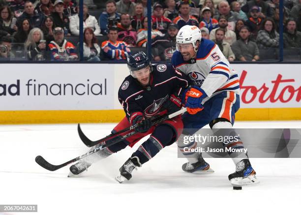 Cody Ceci of the Edmonton Oilers and Justin Danforth of the Columbus Blue Jackets battle for the puck during the second period at Nationwide Arena on...