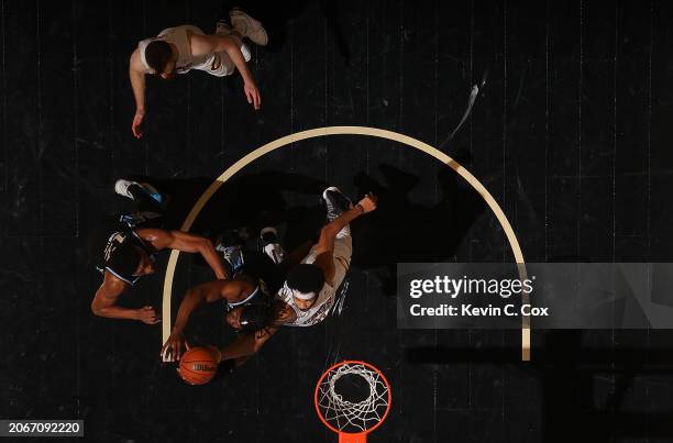 Bruno Fernando and De'Andre Hunter of the Atlanta Hawks battle for a rebound against Jarrett Allen of the Cleveland Cavaliers during the third...