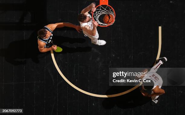 Dean Wade of the Cleveland Cavaliers dunks against Bogdan Bogdanovic of the Atlanta Hawks during the third quarter at State Farm Arena on March 06,...