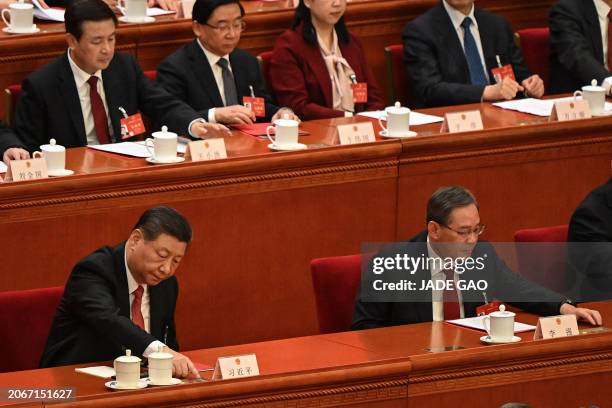 China's President Xi Jinping and China's Premier Li Qiang vote during the closing session of the 14th National People's Congress at the Great Hall of...