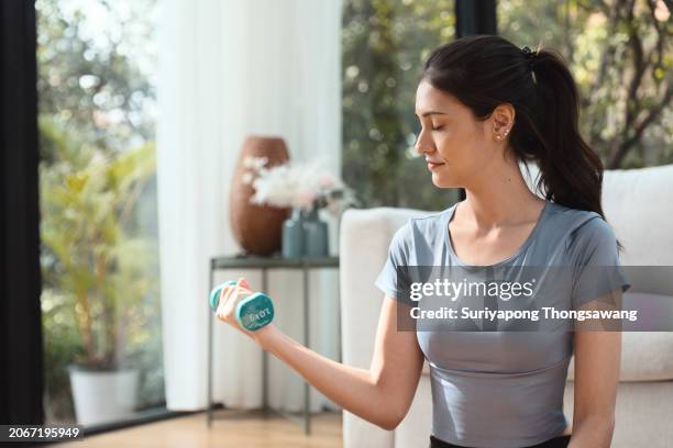 beautiful young woman doing exercise in living room at home, healthy lifestyle or sports training concept. - flatten the curve imagens e fotografias de stock