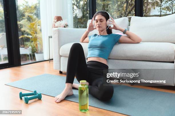 beautiful young woman relax after exercise or yoga in living room at home. healthy lifestyle or sports training concept. - flatten the curve fotografías e imágenes de stock