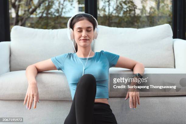 beautiful young woman relax after exercise or yoga in living room at home. healthy lifestyle or sports training concept. - flatten the curve fotografías e imágenes de stock