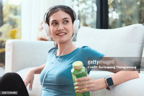 beautiful young woman relax after exercise or yoga in living room at home. healthy lifestyle or sports training concept. - flatten the curve 個照片及圖片檔