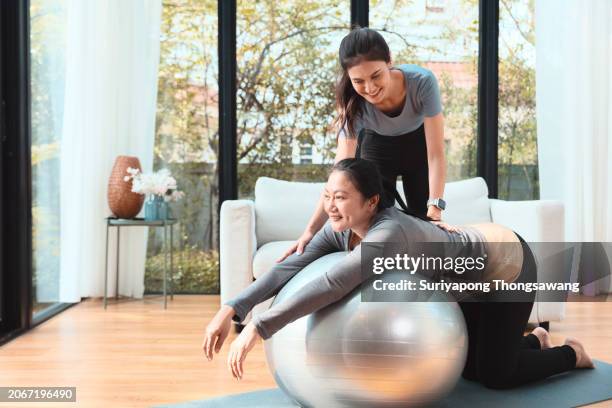 daughter and mother doing exercise or yoga in living room at home. healthy lifestyle or sports training concept. - flatten the curve 個照片及圖片檔