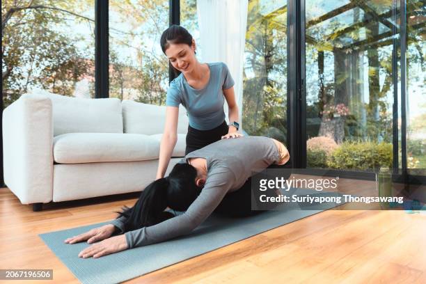 daughter and mother doing exercise or yoga in living room at home. healthy lifestyle or sports training concept. - kurve abflachen stock-fotos und bilder