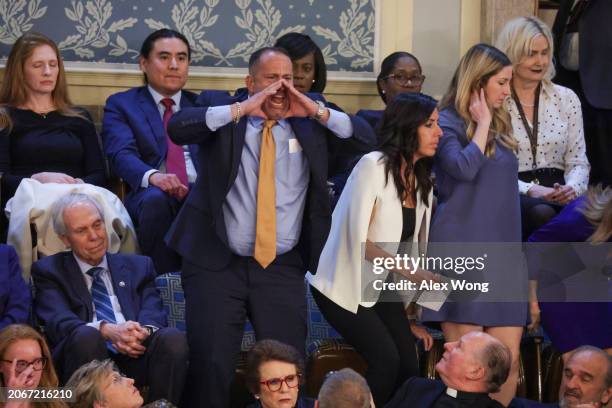 Heckler yells out as U.S. President Joe Biden delivers the State of the Union address during a joint meeting of Congress in the House chamber at the...