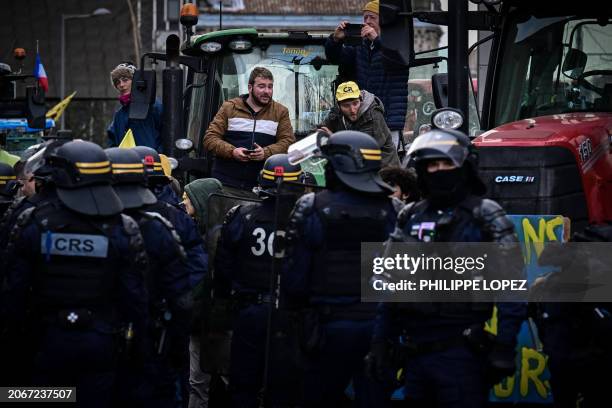 French farmers protest on their tractors facing French Republican Security Corps police officers outside the Aquitaine Regional Council in Bordeaux,...