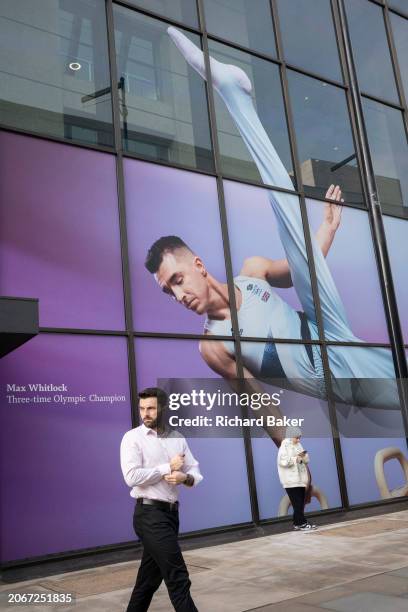 With months before the 2024 Paris Olympics, members of the public pass beneath a huge image of Team GB gymnast and previous Olympic gold medalist,...