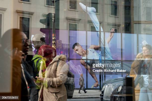 With months before the 2024 Paris Olympics, members of the public pass beneath a huge image of Team GB gymnast and previous Olympic gold medalist,...