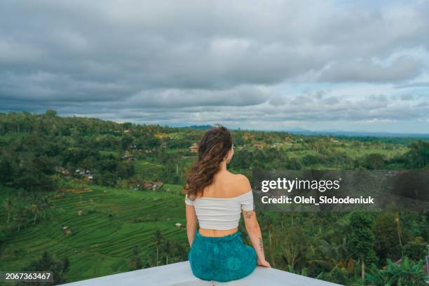 woman sitting on the balcony and looking at jatiluwih rice fields - jatiluwih rice terraces stock pictures, royalty-free photos & images