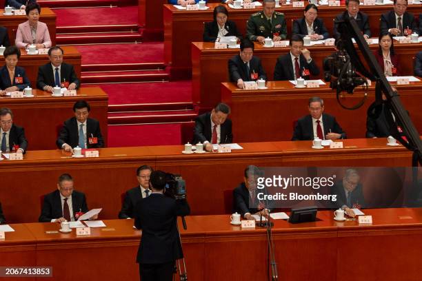 Xi Jinping, China's president, center, casts a ballot during the closing of the Second Session of the 14th National People's Congress at the Great...