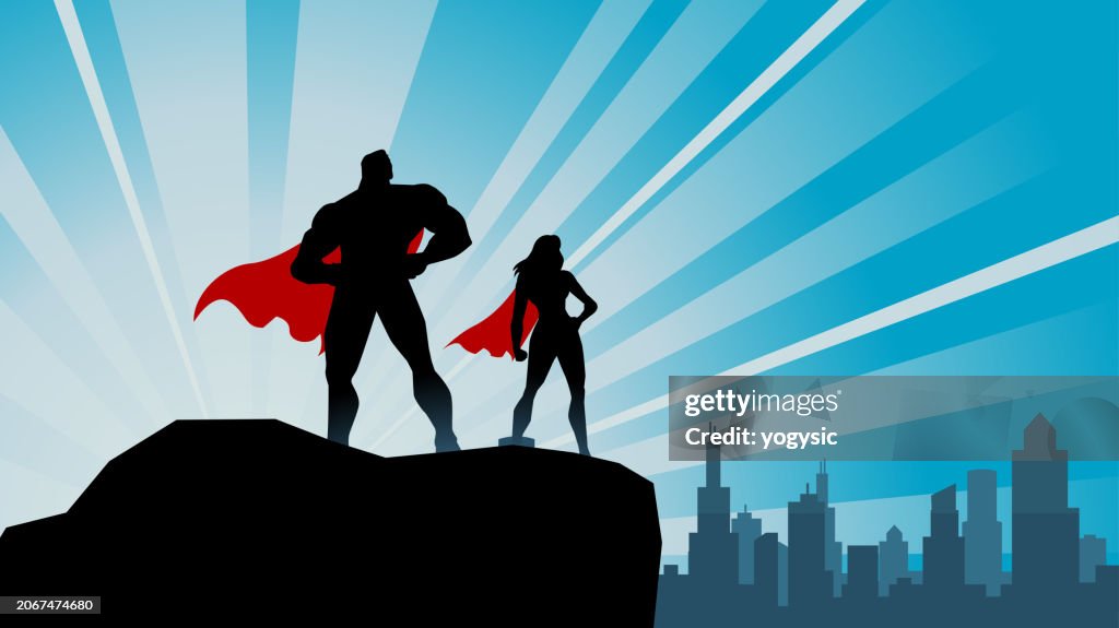 Vector Superhero Duo Silhouette on a Rock with City Skyline Background Stock Illustration
