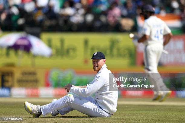 England captain Ben Stokes falls over while fielding as Shubman Gill and Rohit Sharma of India score runs during day two of the 5th Test Match...