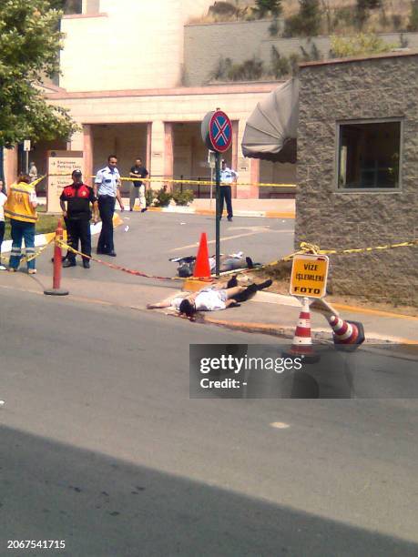 Picture taken with a mobile telephone shows an unidentified man lies on the ground lifeless after an attack outside the US consulate in Istanbul on...