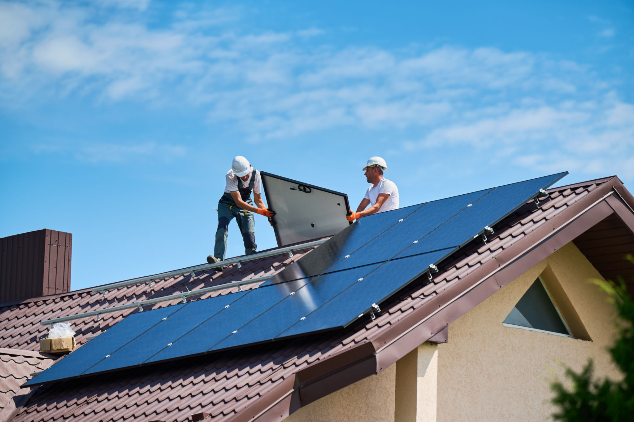 Workers building solar panel system on roof of house. Installers carrying photovoltaic solar module Workers building solar panel system on roof of house. Installers carrying photovoltaic solar module