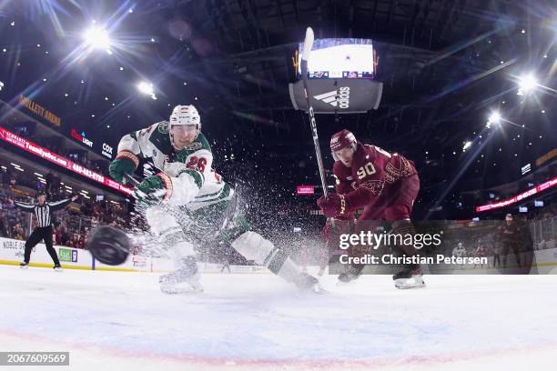 Connor Dewar of the Minnesota Wild scores an empty-net goal past J.J. Moser of the Arizona Coyotes during the third period of the NHL game at Mullett...