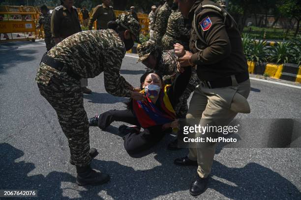 Police officers are detaining a Tibetan activist from the Tibetan Youth Congress during a protest to mark the anniversary of the 65th Tibetan...