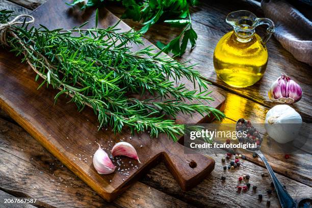 ramitas de romero fresco en tabla de cortar - europeo del sur fotografías e imágenes de stock