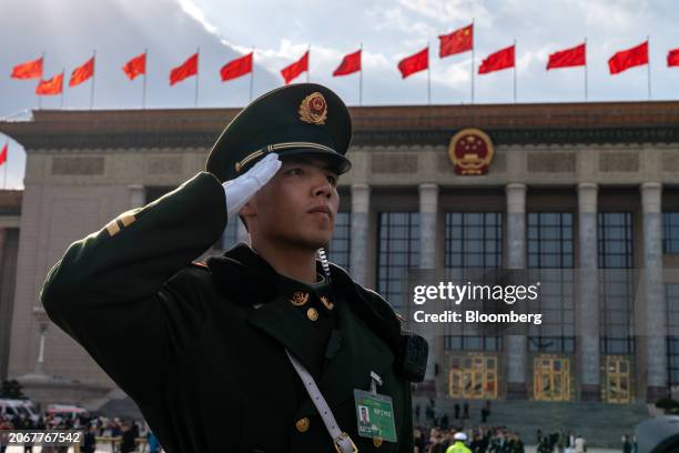 Member of the People's Liberation Army salutes outside the Great Hall of the People following the closing of the Second Session of the 14th National...