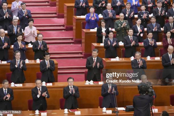 Chinese President Xi Jinping claps as the National People's Congress closes at the Great Hall of the People in Beijing on March 11, 2024.