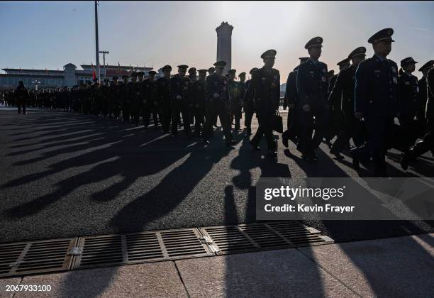 Chinese military delegates walk in a line as they arrive at the second plenary session of the National Peoples Congress at the Great Hall of the...