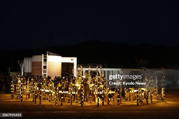 People look at lanterns placed at Okawa Elementary School in Ishinomaki in Miyagi Prefecture, northeastern Japan, on March 11 the 13th anniversary of...