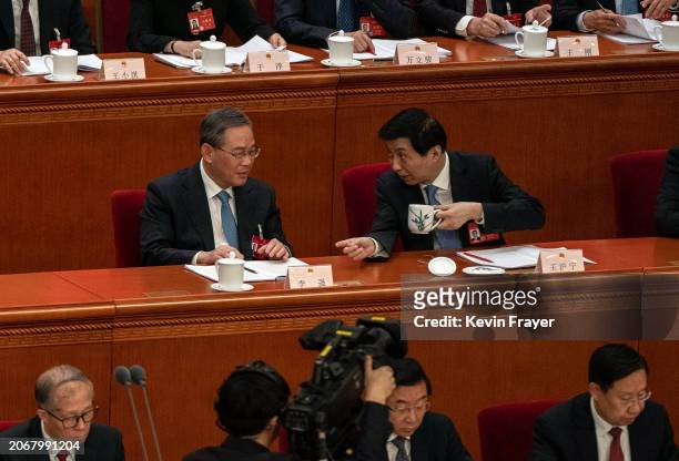 Premier Li Qiang and Standing Committee member Wang Huning, right, talk at the second plenary session of the National Peoples Congress at the Great...