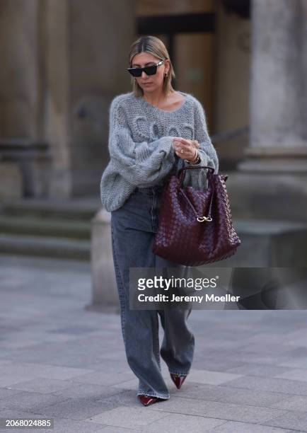 Aylin Koenig seen wearing Celine black sunglasses, gold earrings, Loewe grey logo knit oversized sweater, Massimo Dutti grey wide leg baggy denim /...