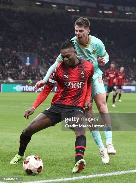 Rafael Leao of AC Milan is challenged by Lukas Masopust of Slavia Prague during the UEFA Europa League 2023/24 round of 16 first leg match between AC...