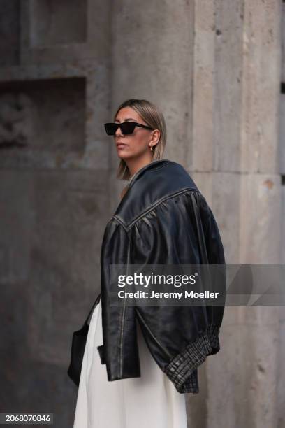 Aylin Koenig seen wearing Saint Laurent black sunglasses, Miu Miu black oversized leather jacket, By Aylin Koenig white bandeau long dress, on March...