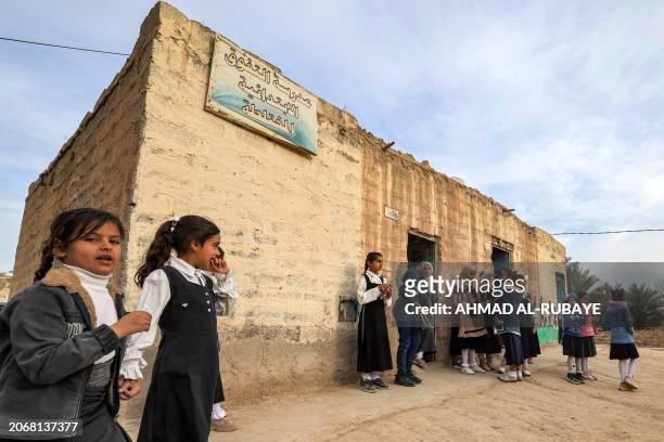 Students gather outside one of the mud brick buildings with thatched roofs on a farm, used as makeshift classrooms by the mixed-gender al-Tafawuq...