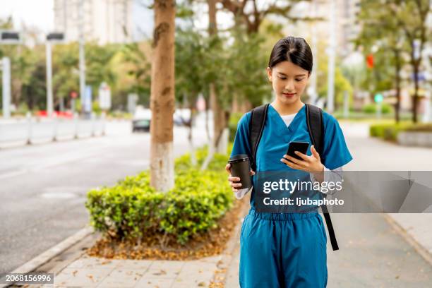 after shift, female surgeon checks on patient through mobile app - self service stock pictures, royalty-free photos & images
