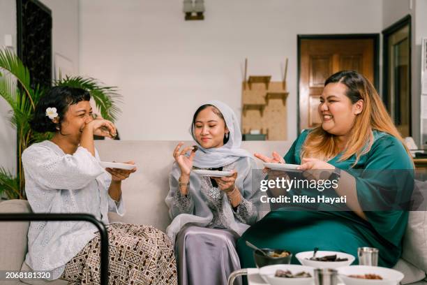 friends celebrating raya eid al-fitr with traditional foods - malaysian culture stock pictures, royalty-free photos & images