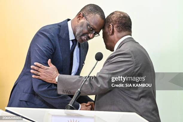 Ivorian President Alassane Ouattara and the president of the Democratic Party of Cote d'Ivoire Tidjane Thiam shake hands during a press conference...