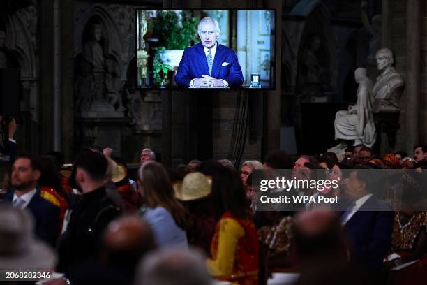 Guests watch a video of Britain's King Charles III delivering a message during the 2024 Commonwealth Day Service at Westminster Abbey on March 11,...