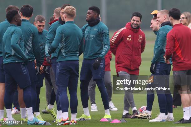 Arsenal manager Mikel Arteta smiling as he watches his squad during Arsenal FC training session ahead of their Champions League match against FC...
