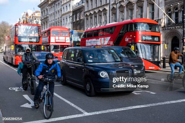 Cyclists in traffic on Whitehall on 6th March 2024 in London, United Kingdom. Cycling is a very popular mode of transport in the capital as people...