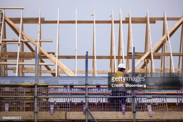 Worker lays insulation material on the roof of a new home at a Persimmon Plc residential property construction site in Braintree, UK, on Monday,...