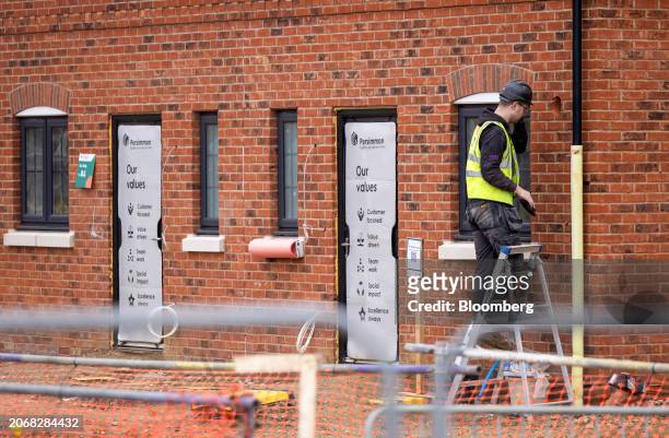 An employee works on the outside of a home at a Persimmon Plc residential property construction site in Braintree, UK, on Monday, March 11, 2024....