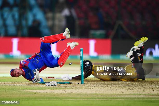 Karachi Kings' wicket-keeper Tim Seifert runs out Peshawar Zalmi's Rovman Powell during the Pakistan Super League Twenty20 cricket match between...