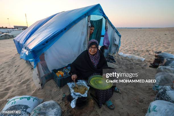 Palestinian woman prepares to eat an iftar meal, the breaking of fast, on the first day of the Muslim holy fasting month of Ramadan, at a camp for...