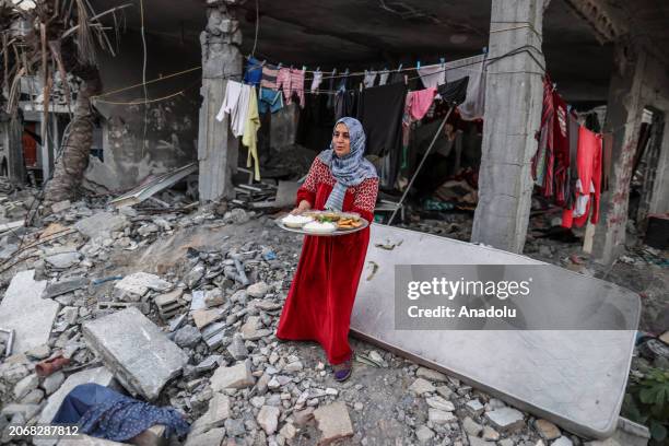 Palestinian woman makes preparations to have first fast-breaking dinner among the rubbles of her destroyed house, due to Israeli attacks, on the...