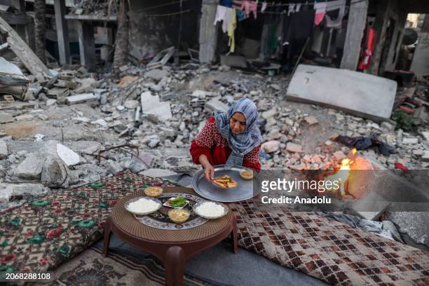Palestinian woman makes preparations to have first fast-breaking dinner among the rubbles of her destroyed house, due to Israeli attacks, on the...