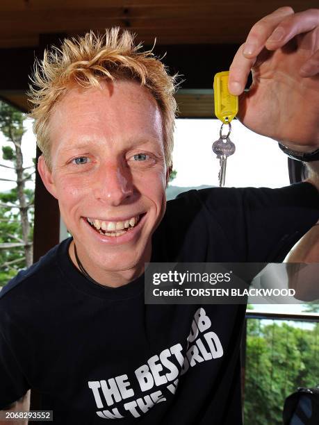 Ben Southall of Britain displays the key to the 'Blue Pearl' lodge which will be his home for six months a day after winning the 'Best Job In The...